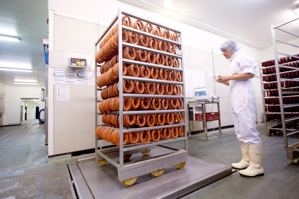 homme qui vérifie le poids d'un chariot de saucissons dans l'usine Berni